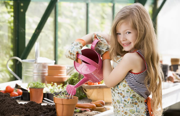 bambina che annaffia le piante da sola